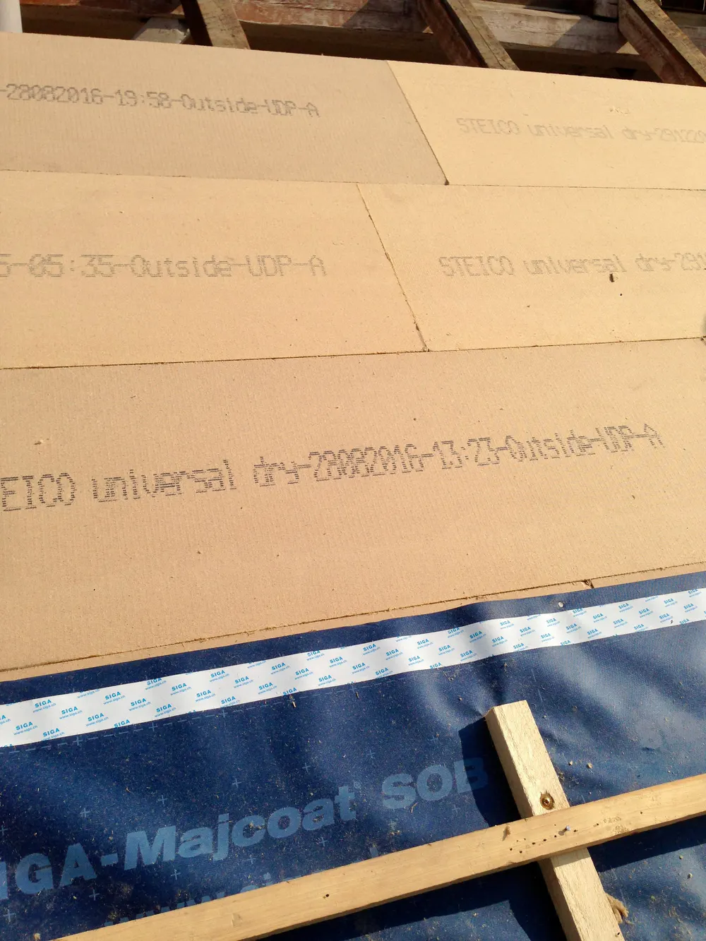 Dämmplatten mit Text "STEICO universal dry" und blauer Majcoat Sol Folie auf einem Dach.